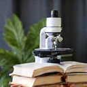 Microscopio y libros, simbolizando el enfoque científico en nutrición.